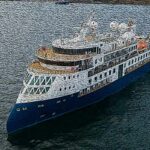 This is a ship on the ocean owned by the company Vantage Deluxe World Travel.